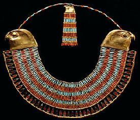 This beaded collar has a beaded pattern of alternating rows of turquoise and carnelian.  Both ends terminate with gold falcon heads.  Attached where the necklace hits the back of the neck is a counterpoise with the same characteristics as the front, save for it has a single gold falcon head.